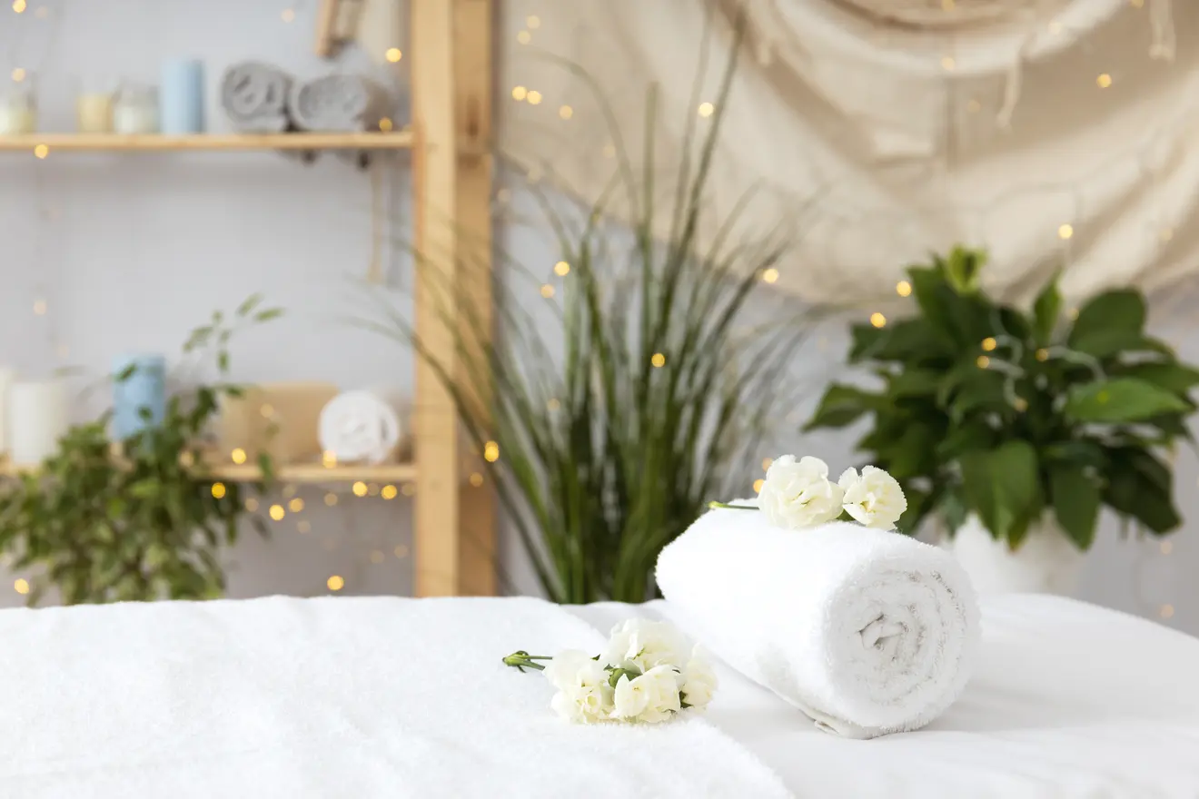 Spa room with rolled towel and flowers